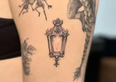 Tatuaje artístico de criaturas mágicas alrededor de la luz.